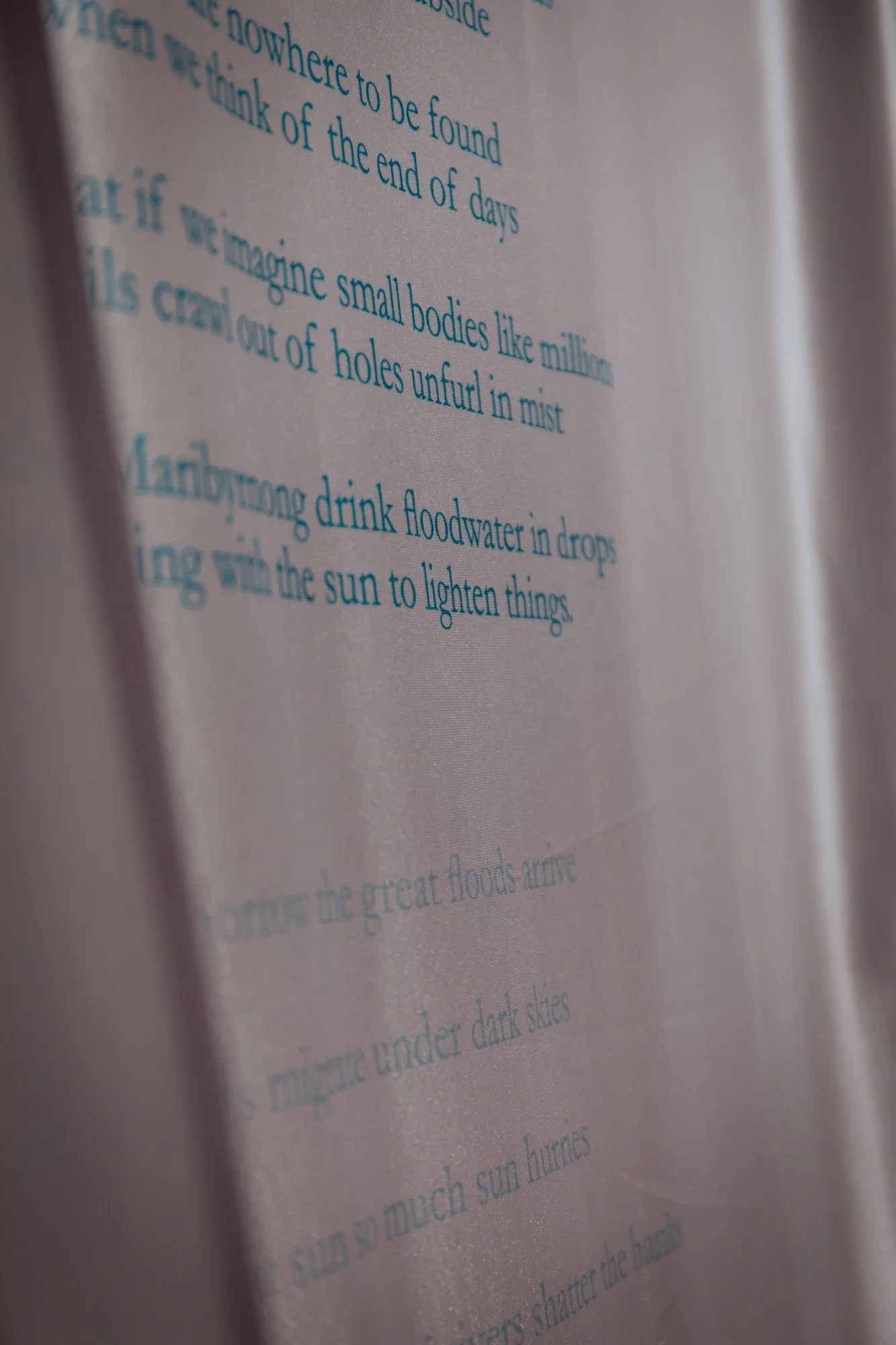 Flood Myth — a poem printed in blue on draped silk, installation view